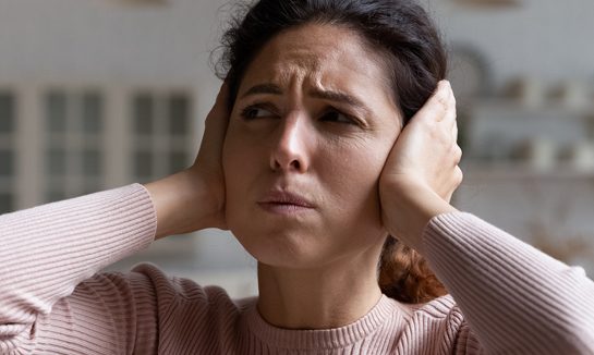 woman covering her ears