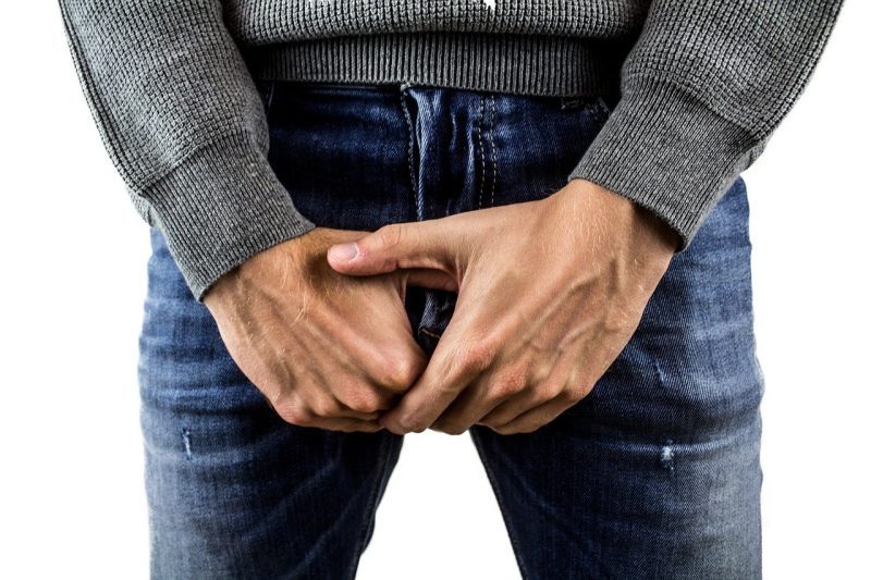 man in jeans covering private area