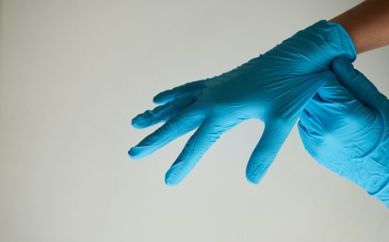 person putting on blue gloves