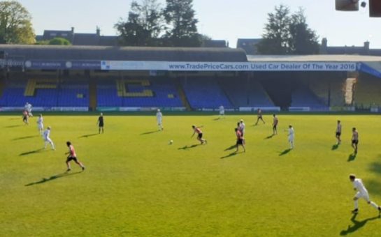 Two football teams playing in a small stadium