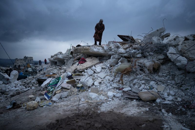 A man stands on the rubble of a destroyed building caused by the earthquake in north-west Syria