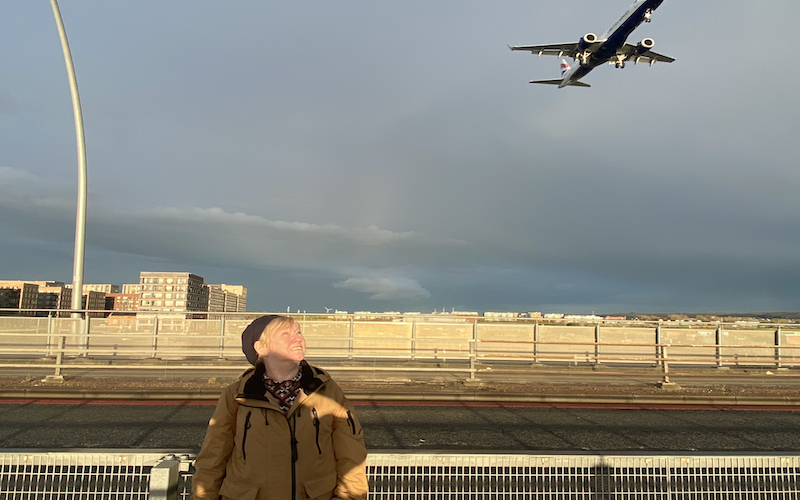 Julie looks up at a plane as it descends to London City Airport