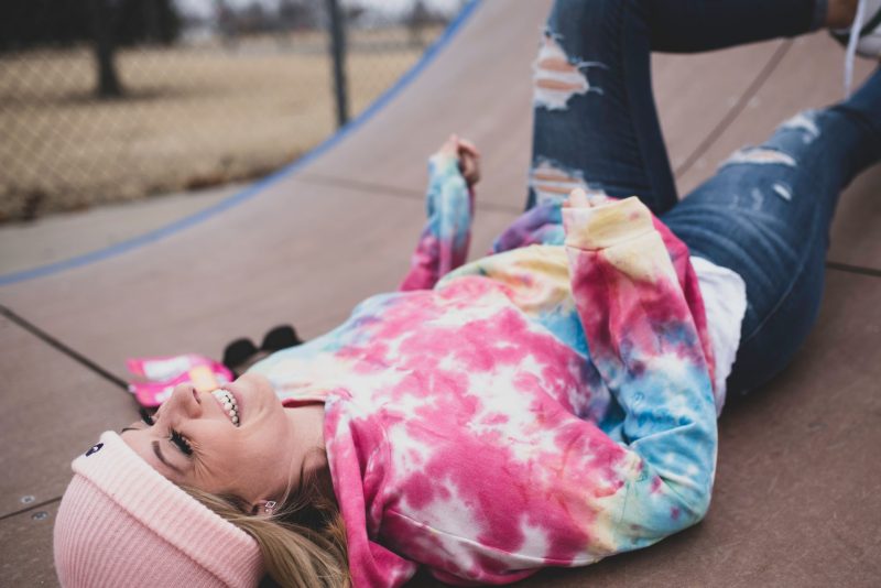 A person wearing tie dye with a hat on