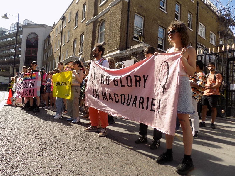 Protesters outside the British LGBT Awards with a pink banner saying 'No Glory in Macquarie'