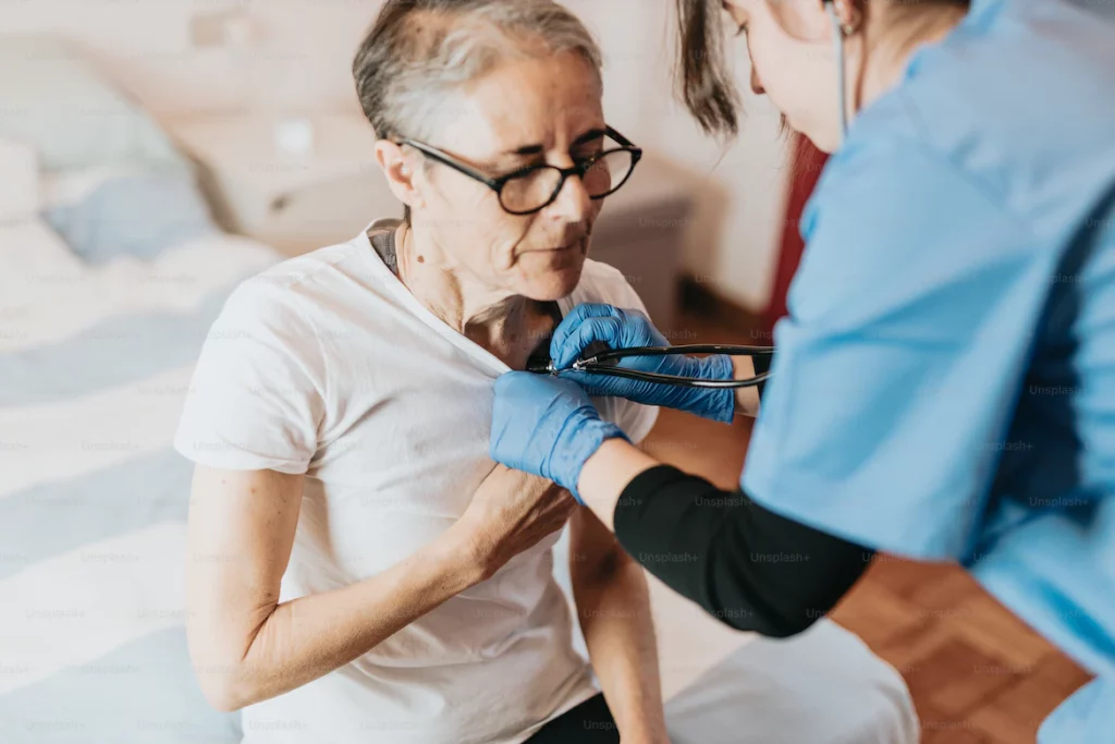 an older woman getting her teeth checked by a nurse 