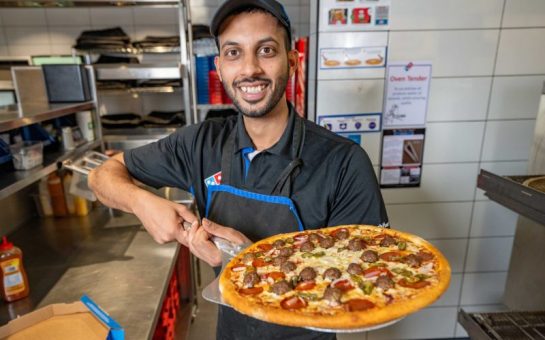 Domino's staff member with his new pizza