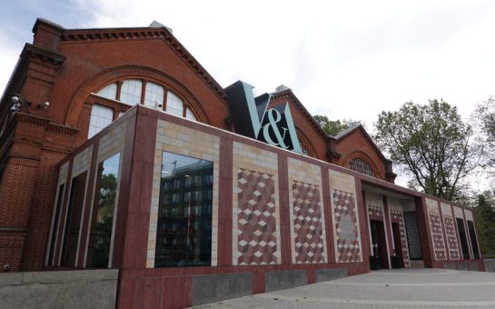 Entrance to the Young V&A Museum in East London. Red brick building with large windows and a blue V&A sign on top. The old "Museum of Childhood" sign can be seen on the front.