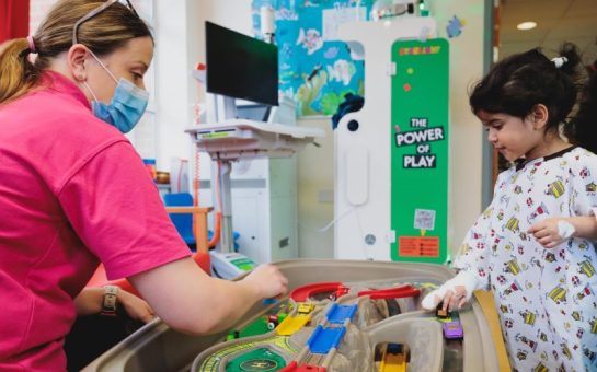 A child and play specialist sitting together