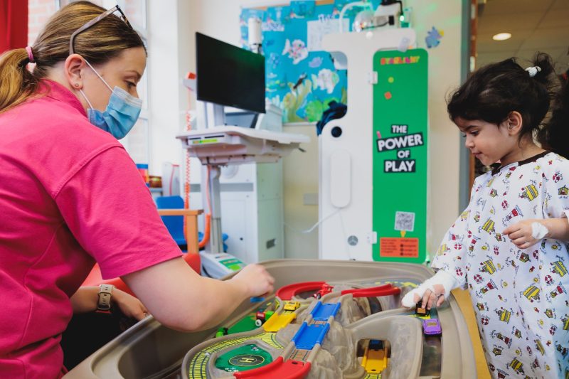 A child and play specialist sitting together