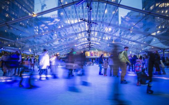 Ice skaters in Canary Wharf ice rink, blurred image of skaters passing by