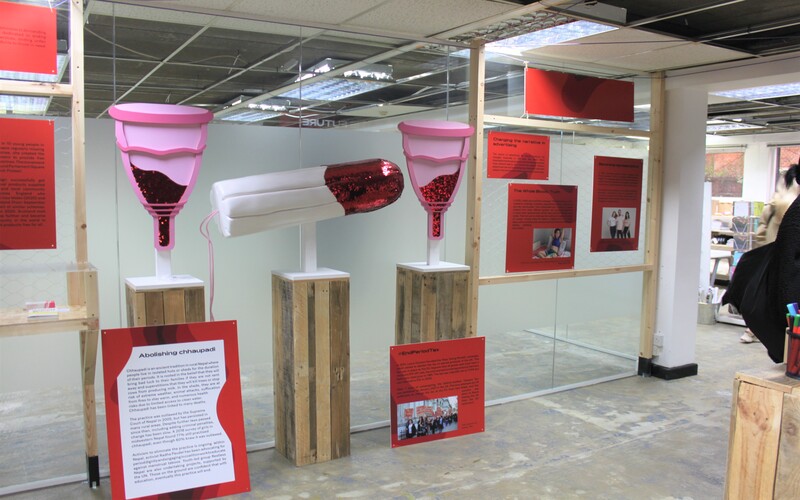 Exhibition at the Vagina Museum. There are giant tampons and diva cups covered in red glitter to represent menstrual blood