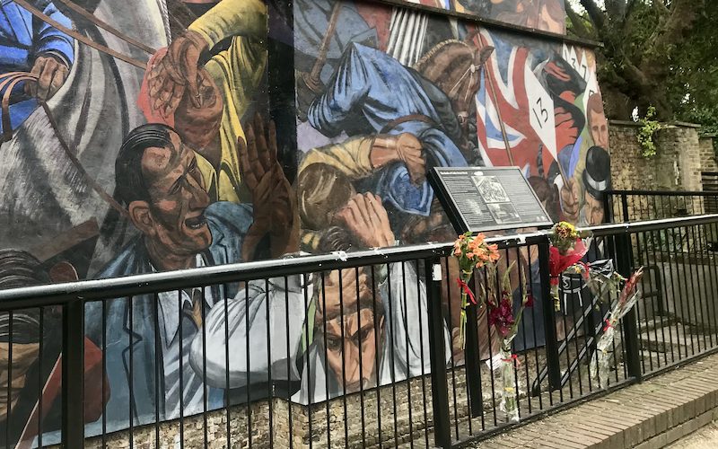 Flowers hung at the mural for the Battle of Cable Street at St Georges Town Hall