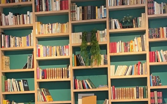 Multiple bookshelves on a wall filled with books.