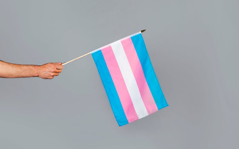A hand showing a transgender flag for Transgender Awareness Week London