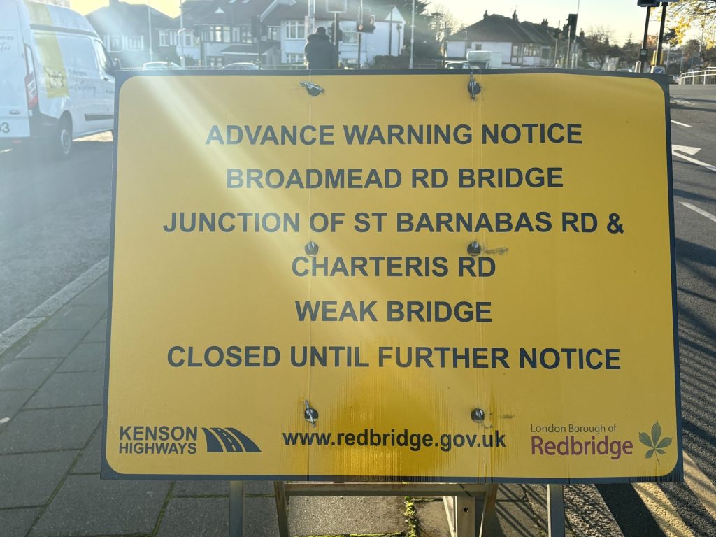 Yellow sign post explaining closure of Broadmead Road. 