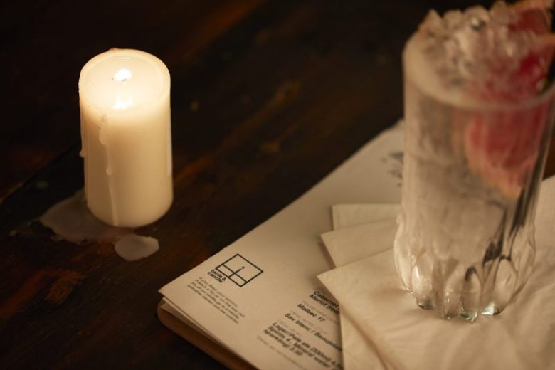 The corner of a menu saying table&candle can be seen with a candle melting in the far corner.