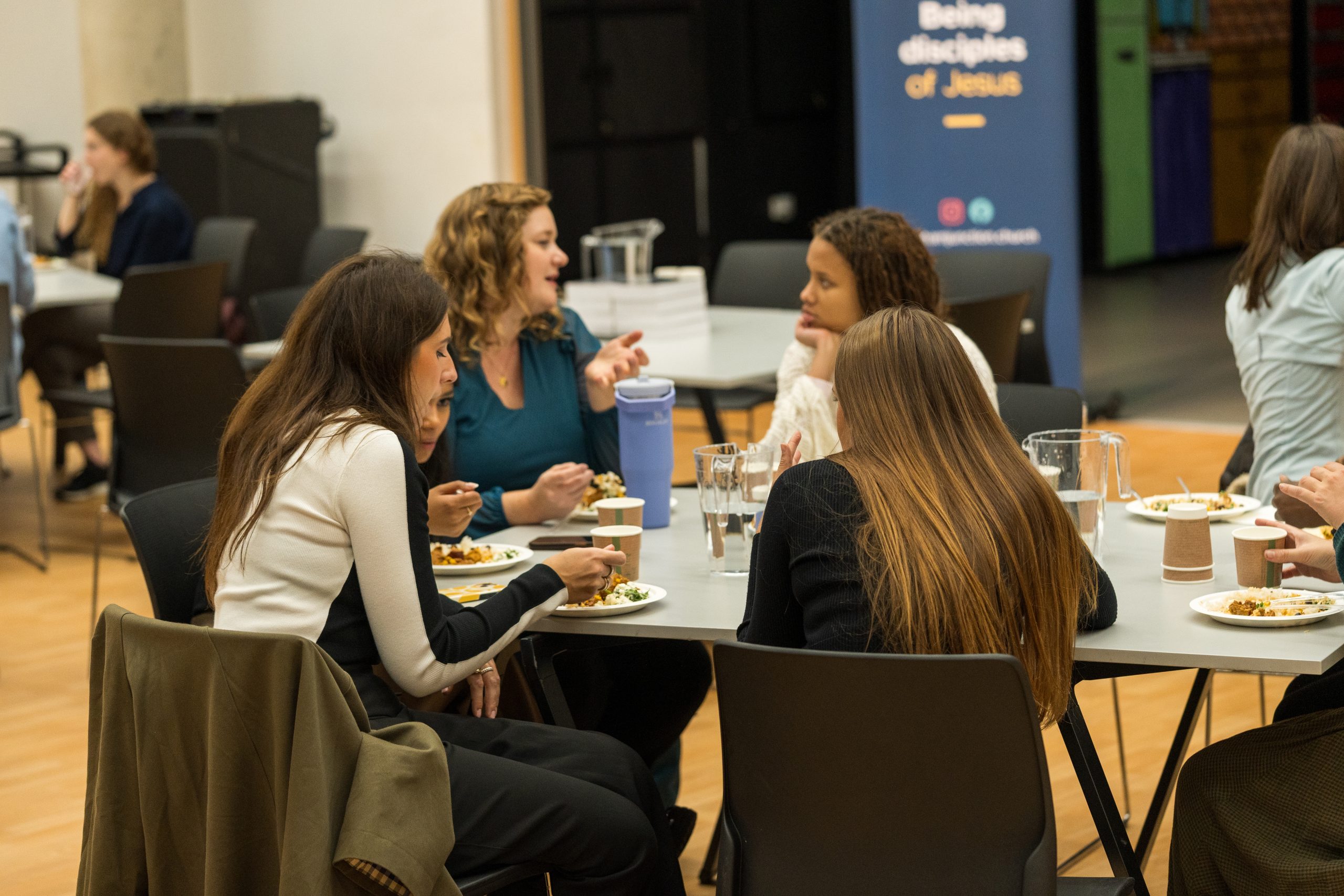 Women chat while eating together at church.