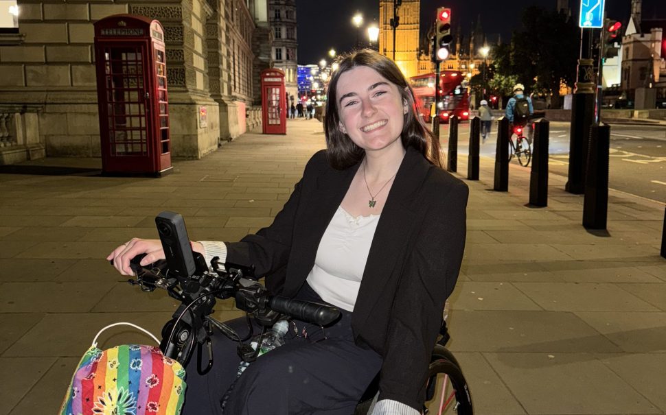 Picture of Zara Beth, an influencer, in a wheelchair on a street in London in front of Big Ben.