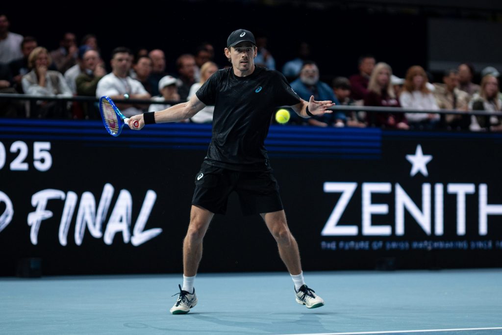 Alex De Minaur hits a tennis ball. 