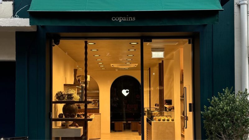 Copains London bakery storefront green canopy with business name and warm bakery interior