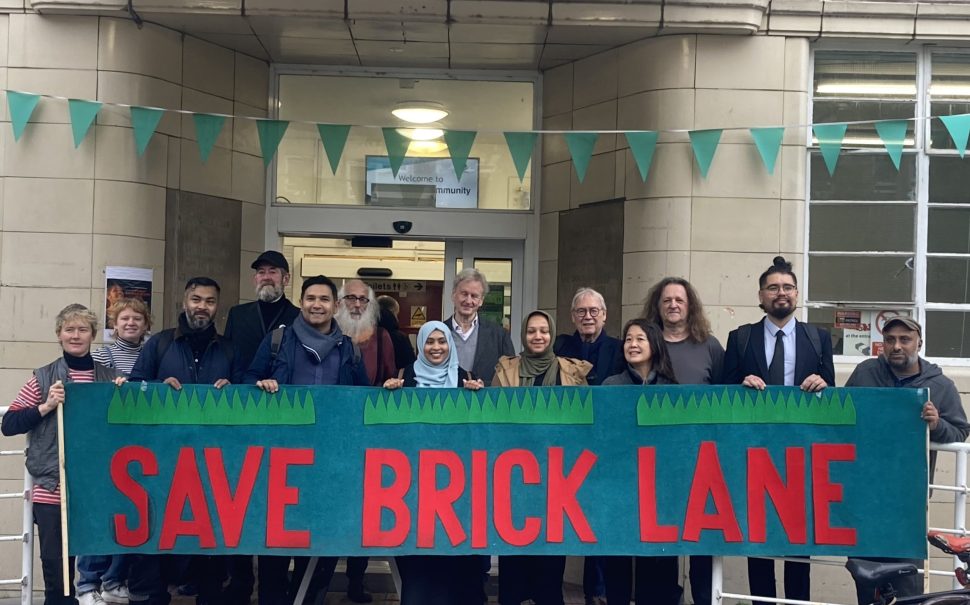 A group holding a placard which reads "Save Brick Lane"