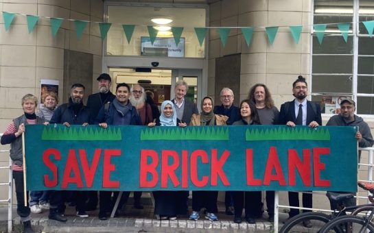 A group holding a placard which reads "Save Brick Lane"