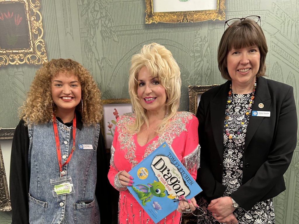 Dolly Parton lookalike Carrie-Anne Rendall standing with Freya Boyd (left) and Helen Hastle (right) from The Dollywood Foundation UK. At the Hackney launch event. 
Image Credit: Clare Cook, The Dollywood Foundation UK. 