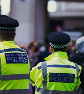 Four Police Officers wearing hi-vis jackets reading 'Metropolitan Police'.