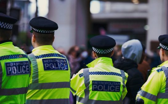 Four Police Officers wearing hi-vis jackets reading 'Metropolitan Police'.