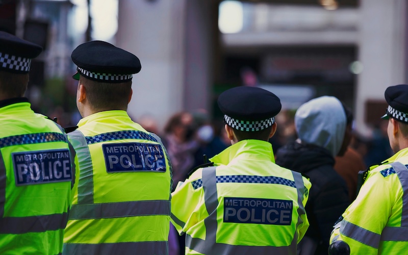 Four Police Officers wearing hi-vis jackets reading 'Metropolitan Police'.