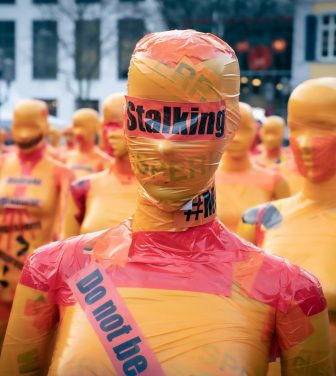Photo of person in tape with stalking labelling across them