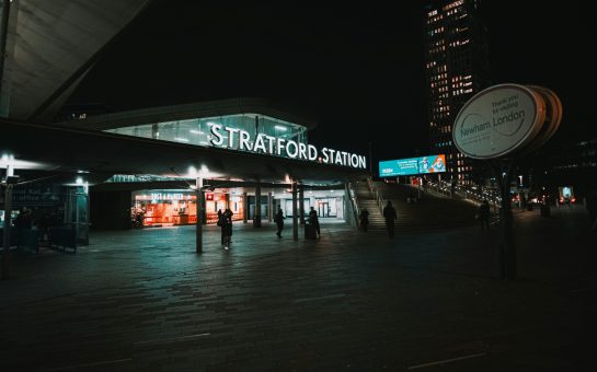 Stratford Station outside at night with Newham sign to one side
