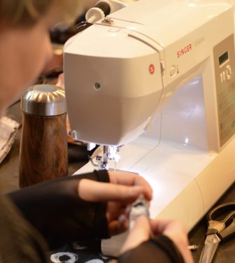 A woman uses a sewing machine to repair clothes