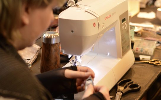 A woman uses a sewing machine to repair clothes