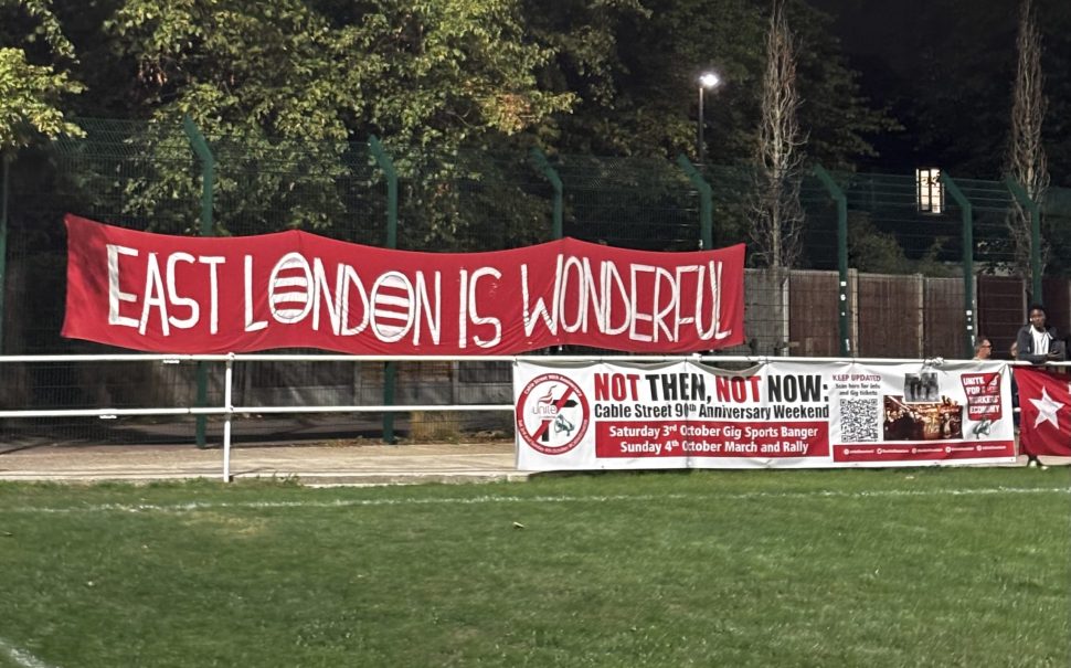 A Clapton CFC Banner reads "East London is Wonderful", alongside a banner marking the 90th anniversary of the Battle of Cable Street