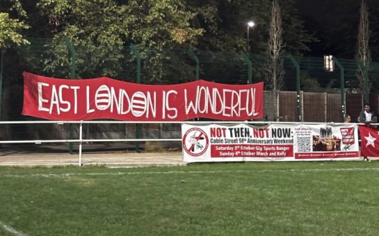 A Clapton CFC Banner reads "East London is Wonderful", alongside a banner marking the 90th anniversary of the Battle of Cable Street