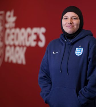 Hijabi coach standing in front of St George's Park sign