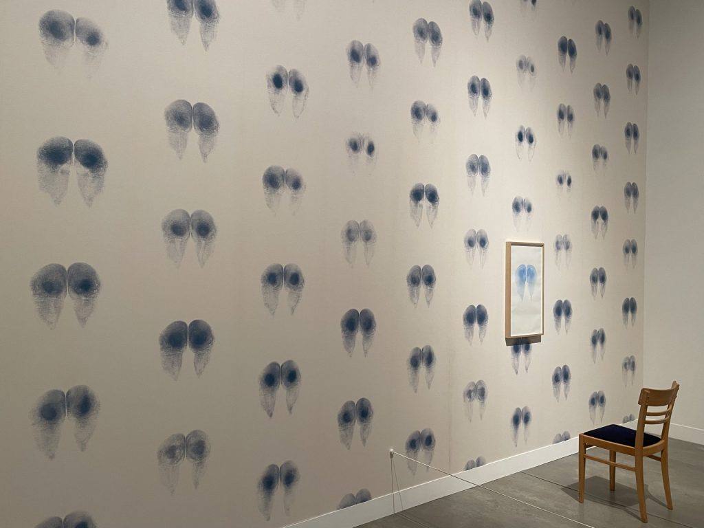 Wallpaper of a printed backside and the chair with a seat of blue ink labelled Bottom Wallpaper by Abigail Lane