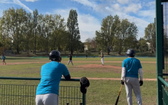 Two baseball players watch an ongoing game