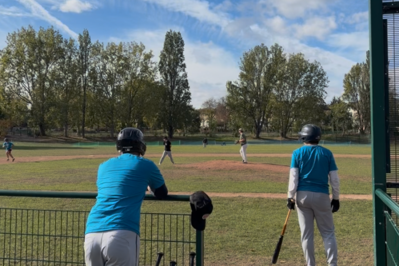 Two baseball players watch an ongoing game