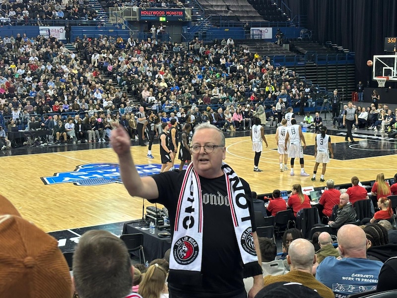Basketball fan Patrick Holgate standing up in crowd section. 