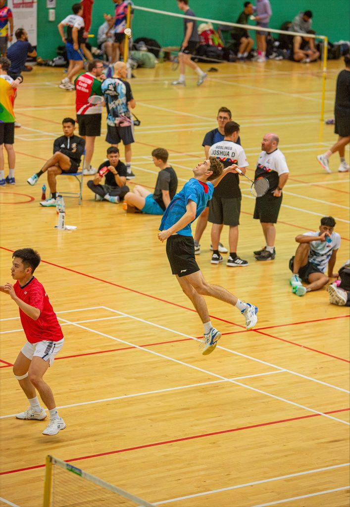 A man jumps for a shot at the London International badminton tournament